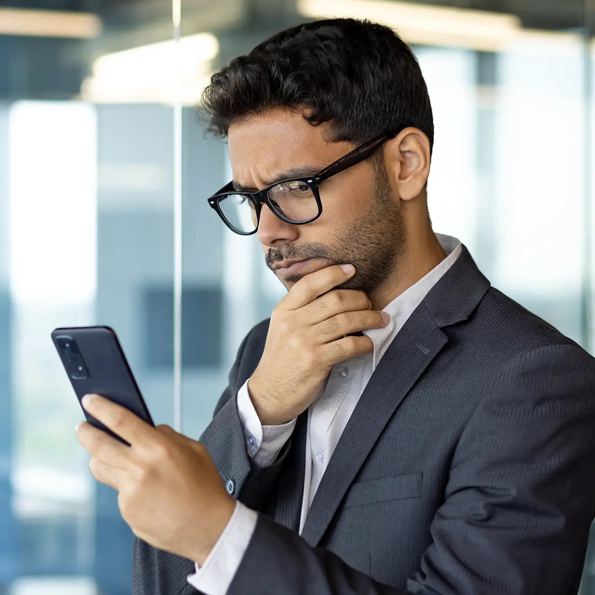 A focused executive studies his phone, weighing whether his team is truly ready